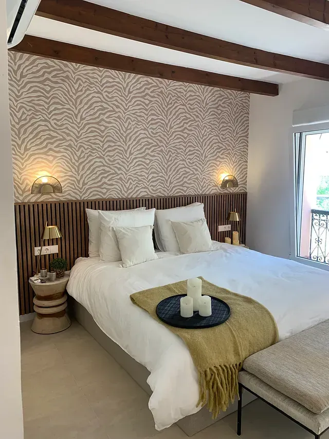 Un dormitorio con una cama grande y un papel pintado con estampado de cebra.