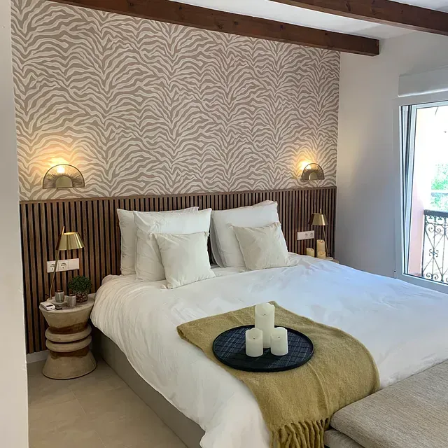 Un dormitorio con una cama king size y una pared con estampado de cebra.