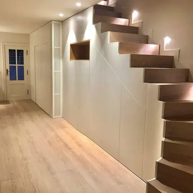 Un pasillo con una escalera que conduce al segundo piso.