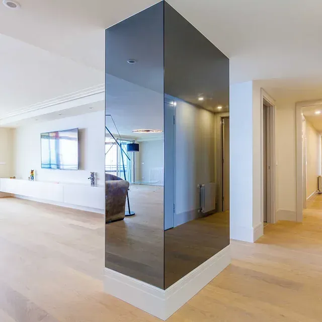 Una sala de estar con un gran espejo en la pared.