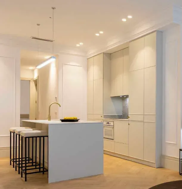 Una cocina con una gran isla y taburetes.