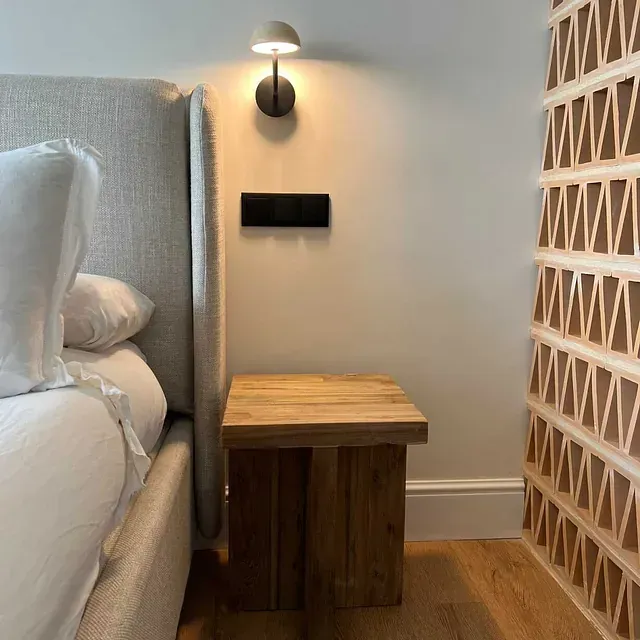 Un dormitorio con una cama y una mesita de noche de madera.