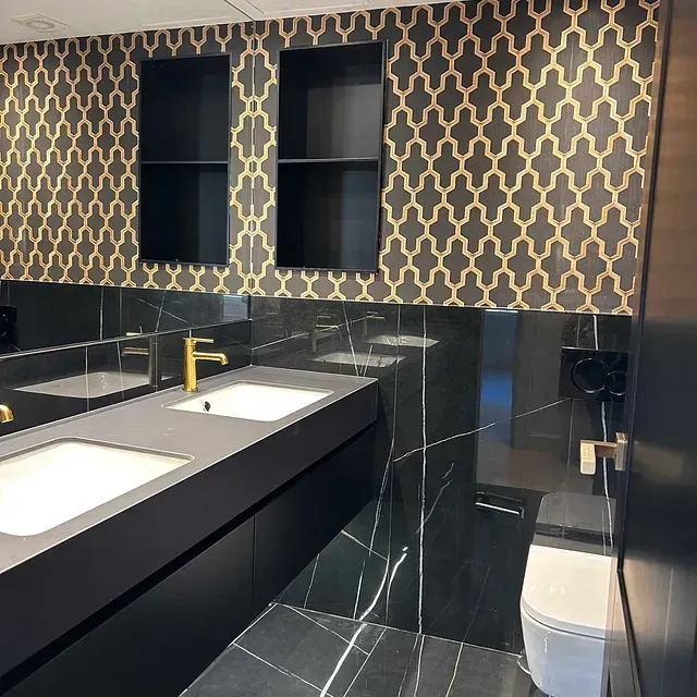 Un baño con lavabo, inodoro y estantes.