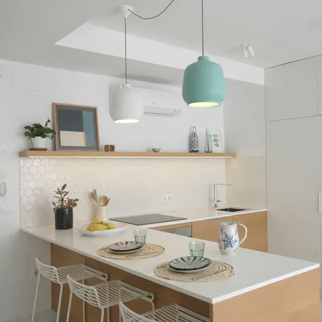 Una cocina con platos y vasos en la encimera.