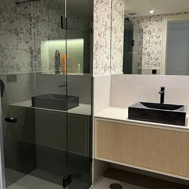 Un baño con lavabo, espejo y ducha.