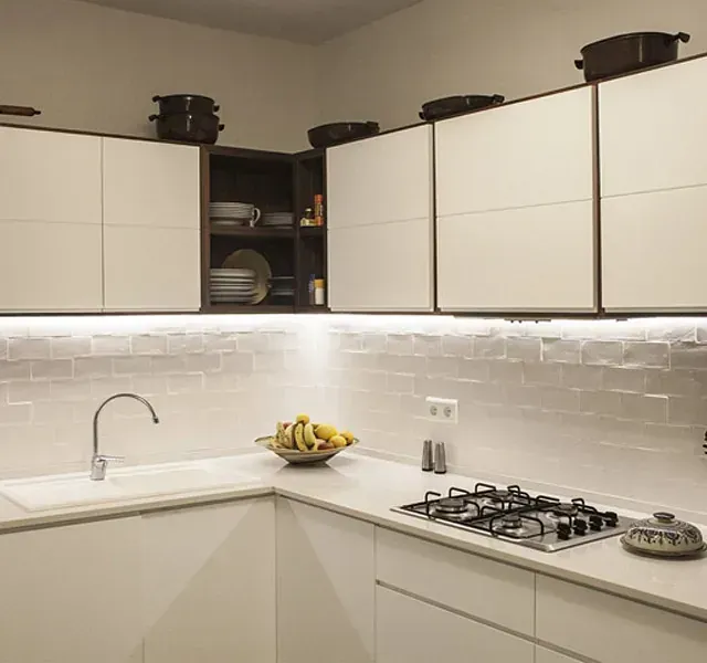 Una cocina con gabinetes blancos y un horno de estufa.