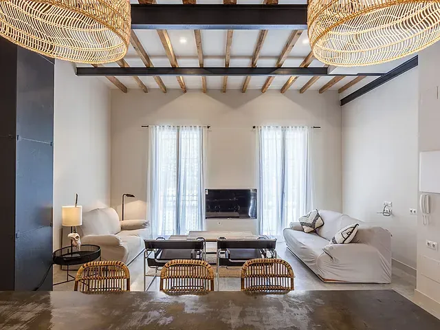 Una sala de estar con sofá, mesa, sillas y chimenea.