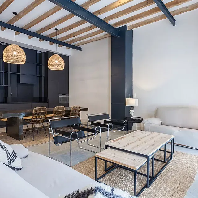 Una sala de estar con sofá, mesa y sillas.