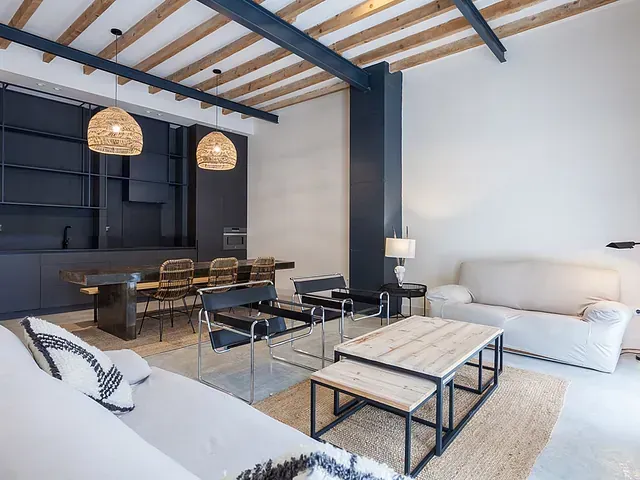 Una sala de estar con sofá, mesa y sillas.