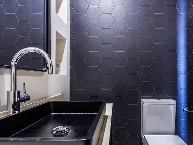 Un baño con lavabo, inodoro y espejo.