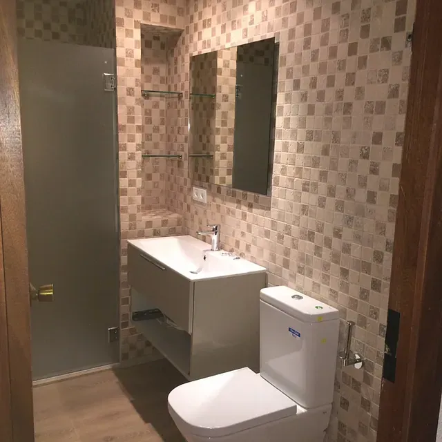 Un baño con inodoro, lavabo y espejo.