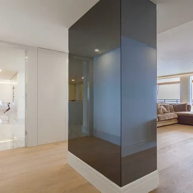 Una sala de estar con un sofá y una pared de cristal.