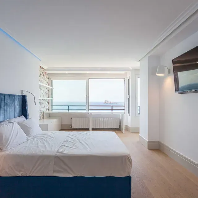 Un dormitorio con una cama grande y un televisor de pantalla plana.