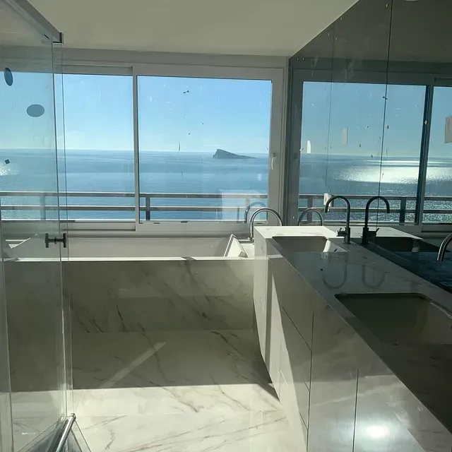 Un baño con bañera y vista al mar.