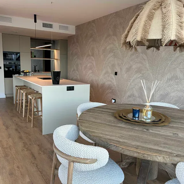 Un comedor con una mesa redonda de madera y sillas.