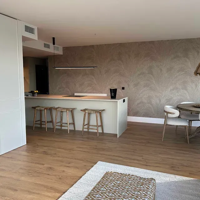 Una sala de estar con una mesa, sillas y taburetes.