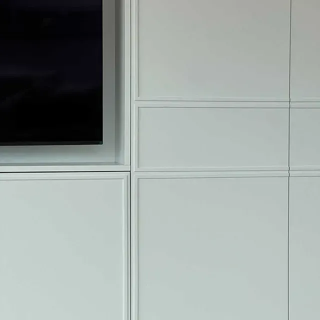 Un primer plano de un mueble blanco con un televisor encima.