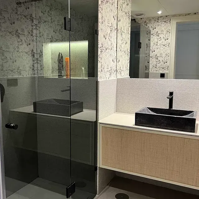 Un baño con lavabo, espejo y ducha.