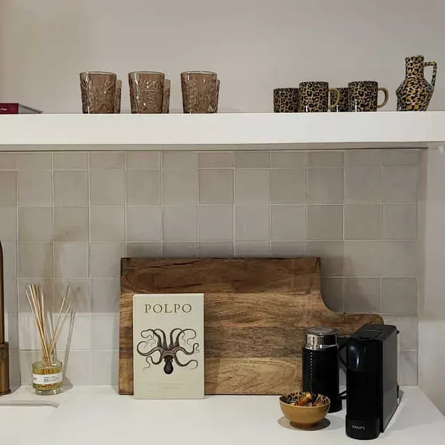 Una encimera de cocina con una tabla de cortar de madera y un libro encima.