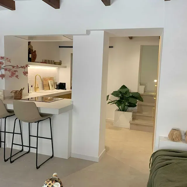 Una sala de estar con una cocina al fondo.