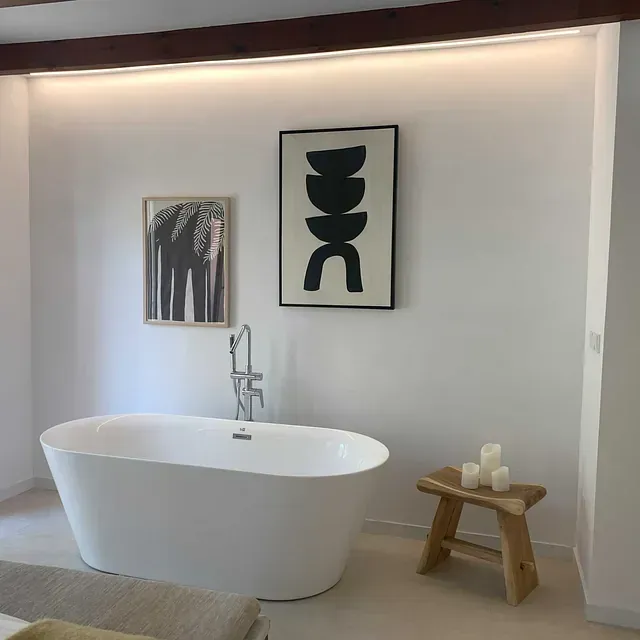 Una bañera en un baño con un cuadro en la pared que dice ddc