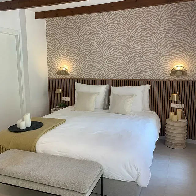 Un dormitorio con una cama grande y un banco.