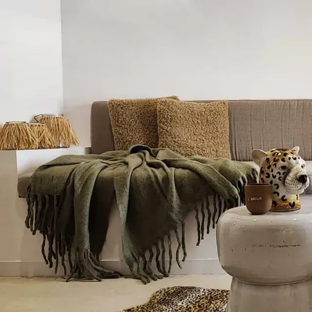 Una sala de estar con un sofá y una mesa con un animal de peluche encima.