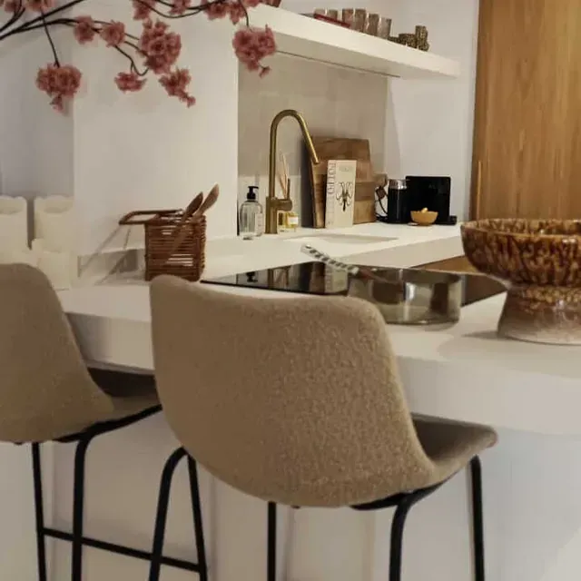 Una cocina con dos sillas y un cuenco en la encimera.