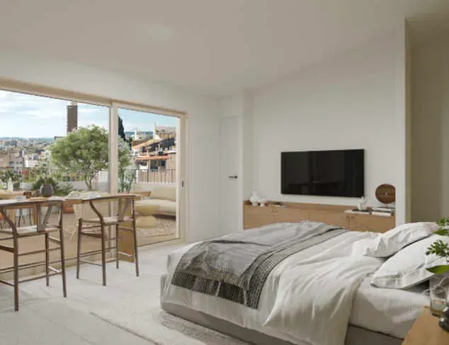 Un dormitorio con una cama, televisión, sillas y un balcón.