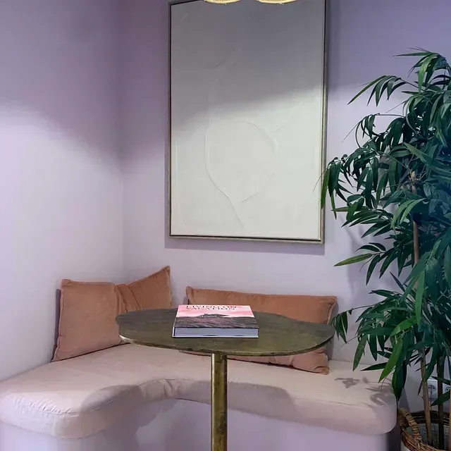 Una sala de estar con un sofá, una mesa y una planta.