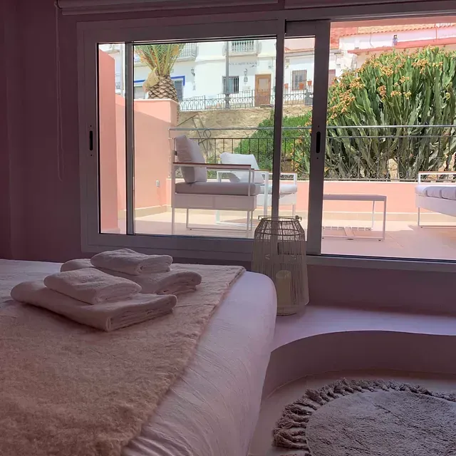 Un dormitorio con una puerta corrediza de vidrio que da a un balcón.