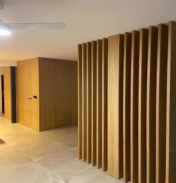 Un pasillo con paredes de madera y un ventilador de techo.