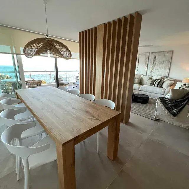 Una sala de estar con una mesa y sillas de madera.