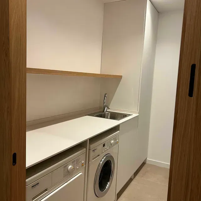 Un lavadero con lavadora, secadora y fregadero.