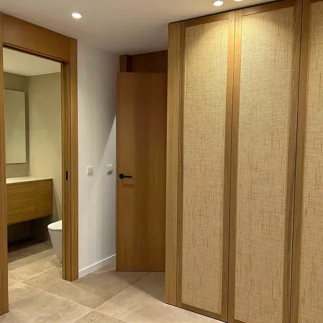 Un pasillo que conduce a un baño con inodoro y lavabo.