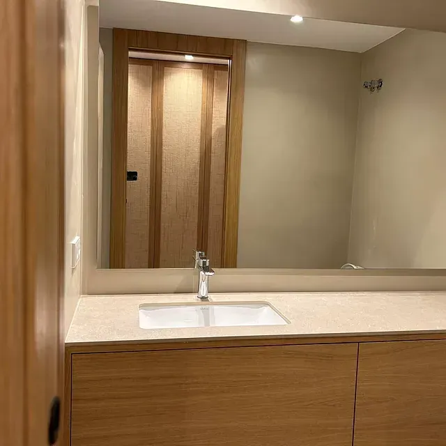 Un baño con lavabo y un espejo grande.