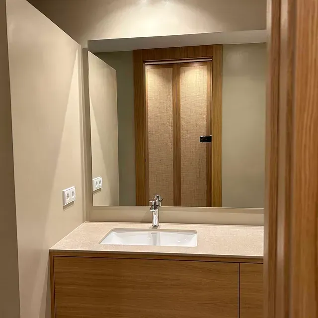 Un baño con lavabo y un espejo grande.