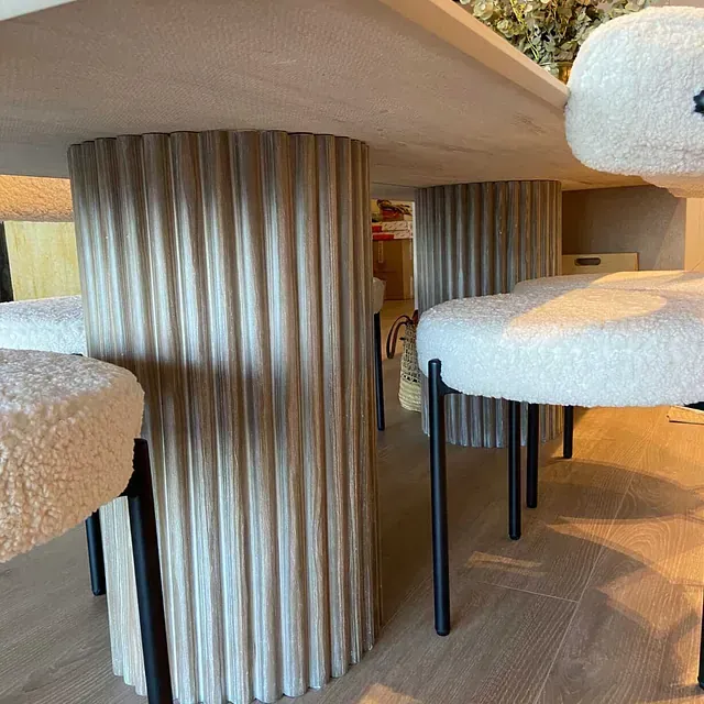 Una mesa de comedor y sillas con base de madera.