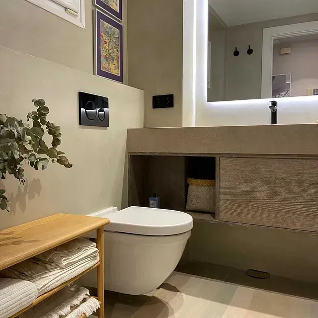 Un baño con inodoro, lavabo y espejo.