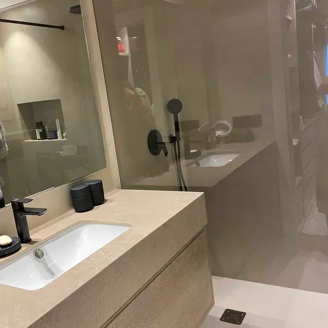 Un baño con lavabo, espejo y ducha.