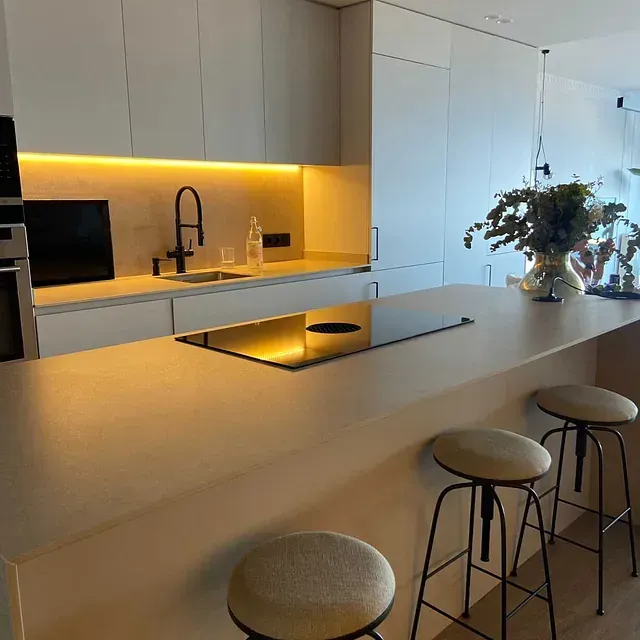 Una cocina con una gran isla y taburetes.