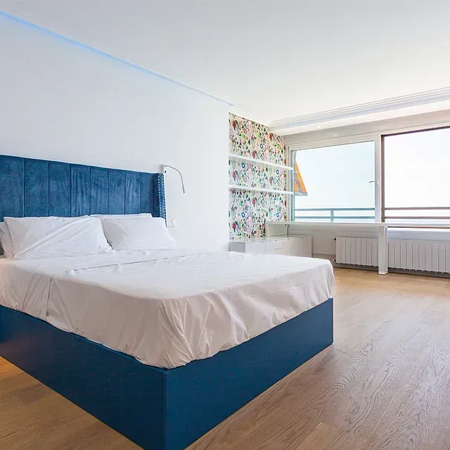 Un dormitorio con una cama grande y una ventana grande.