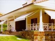 Una casa con un toldo blanco en el porche.
