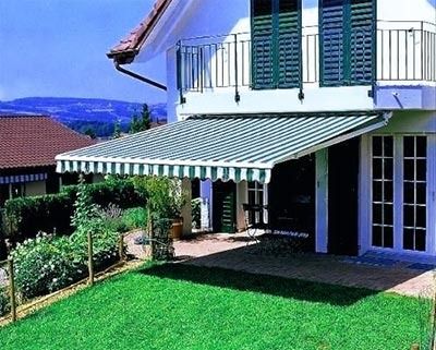 Una casa con un toldo a rayas en el costado.