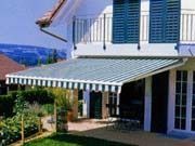 Una casa con un toldo de rayas en el costado.