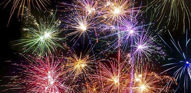 Un montón de fuegos artificiales coloridos explotan en el cielo nocturno.