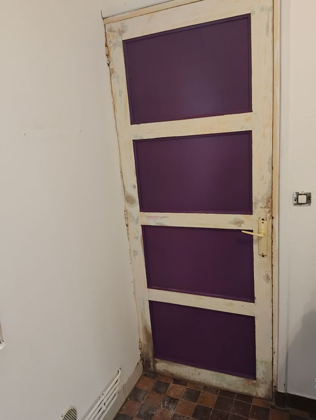 Porte avec trois panneaux dans une pièce à l’intérieur.