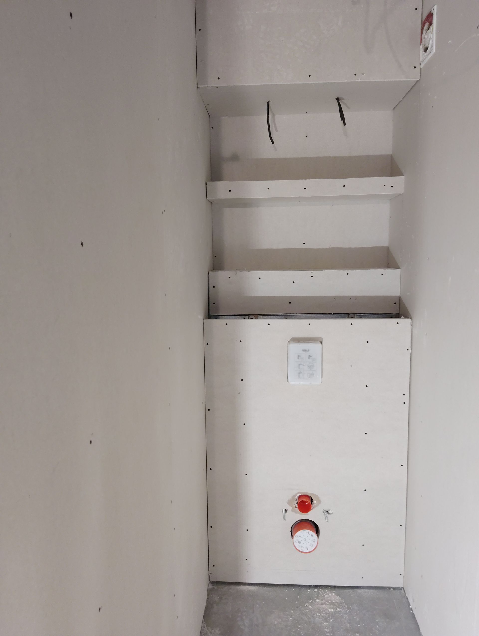 Étroite armoire de rangement avec des étagères murales et un panneau doté de commandes.