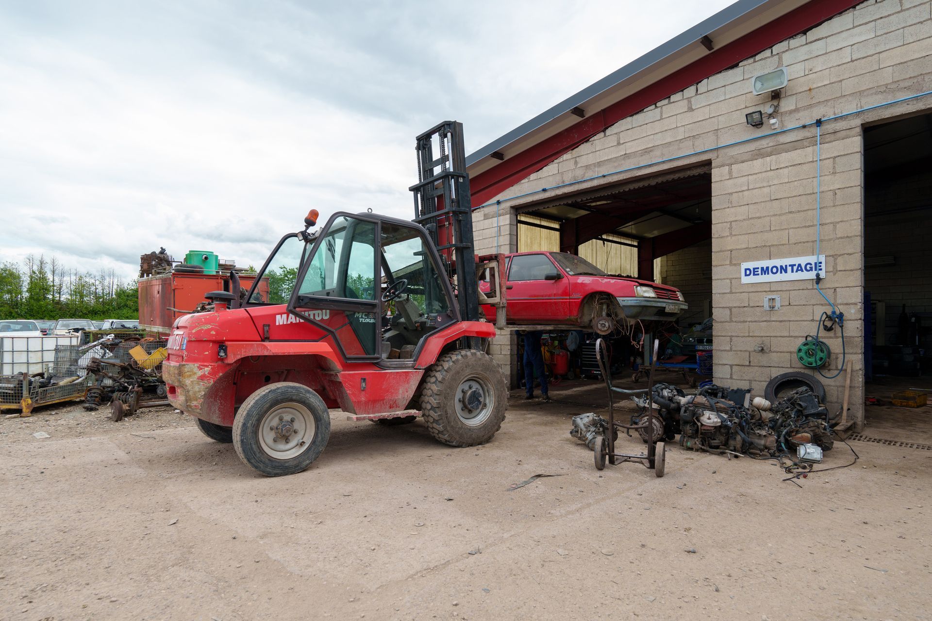 Chariot élévateur amenant une voiture vers une section de démontage