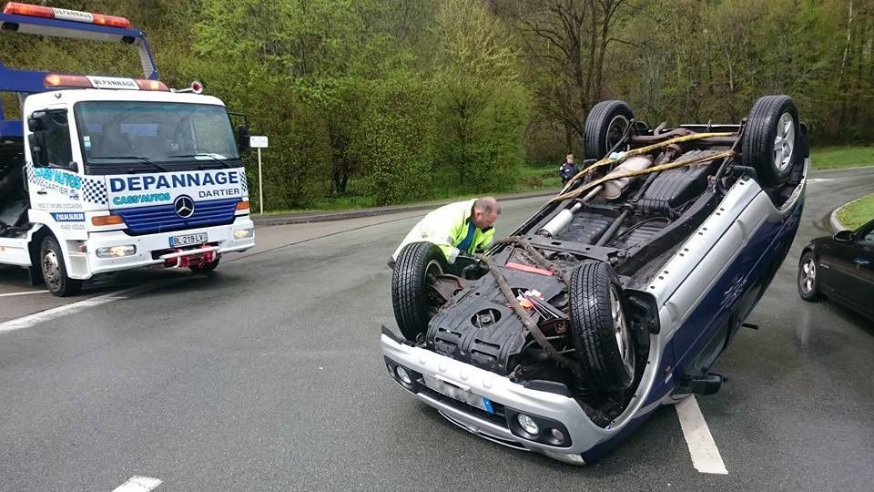 Voiture sur le toit sur une route avec une dépanneuse à proximité